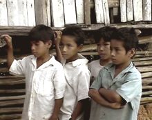 Four boys in front of a house.